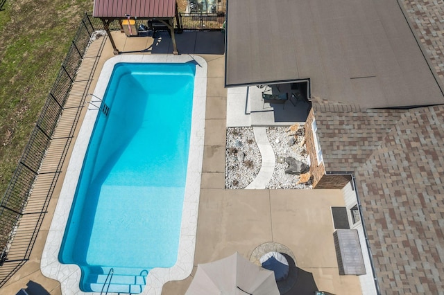 view of swimming pool featuring fence