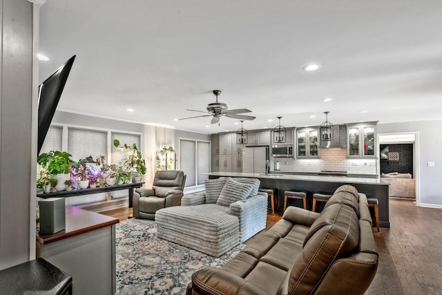 living room featuring ceiling fan, dark wood-style floors, recessed lighting, and ornamental molding