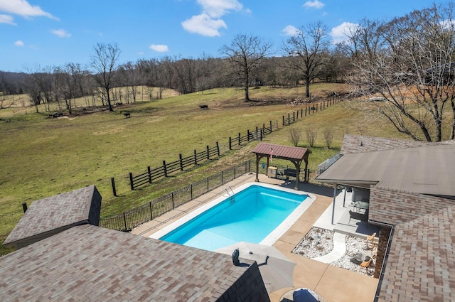 view of pool featuring a lawn, fence, a rural view, a fenced in pool, and a patio area