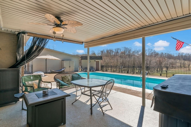 view of pool with a storage unit, a fenced backyard, an outdoor structure, a fenced in pool, and a patio area