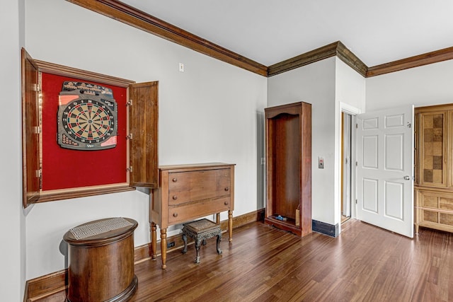 interior space with wood finished floors, baseboards, and ornamental molding