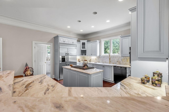 kitchen featuring gray cabinets, stainless steel appliances, glass insert cabinets, crown molding, and tasteful backsplash