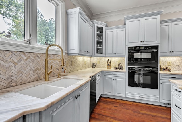 kitchen with dark wood-style flooring, a sink, black appliances, glass insert cabinets, and crown molding