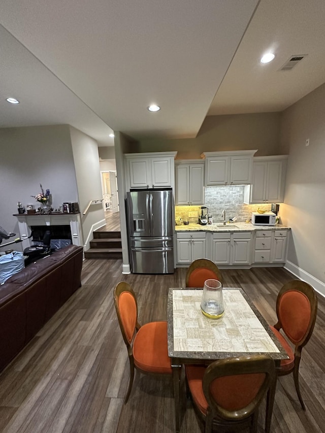 kitchen featuring visible vents, tasteful backsplash, stainless steel fridge, light countertops, and white microwave