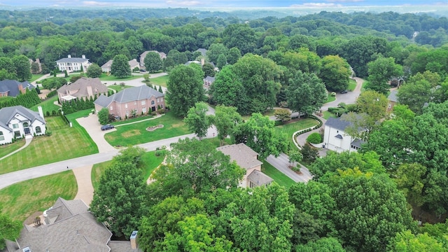 drone / aerial view featuring a residential view and a view of trees