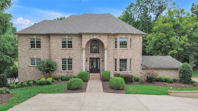 view of front of house featuring brick siding and a shingled roof