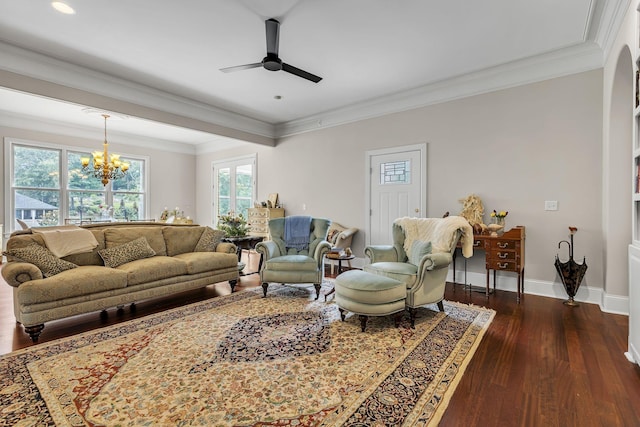 living area featuring ceiling fan with notable chandelier, dark wood-type flooring, baseboards, and ornamental molding