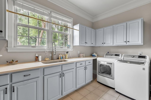 washroom featuring crown molding, separate washer and dryer, light tile patterned flooring, cabinet space, and a sink