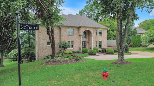 view of front facade with brick siding and a front yard