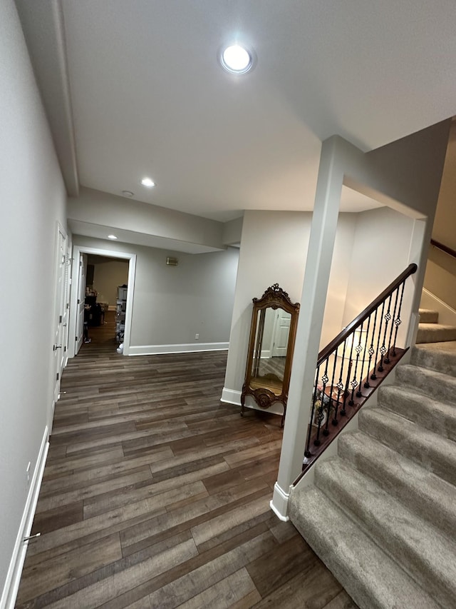 finished below grade area with stairway, recessed lighting, wood finished floors, and baseboards