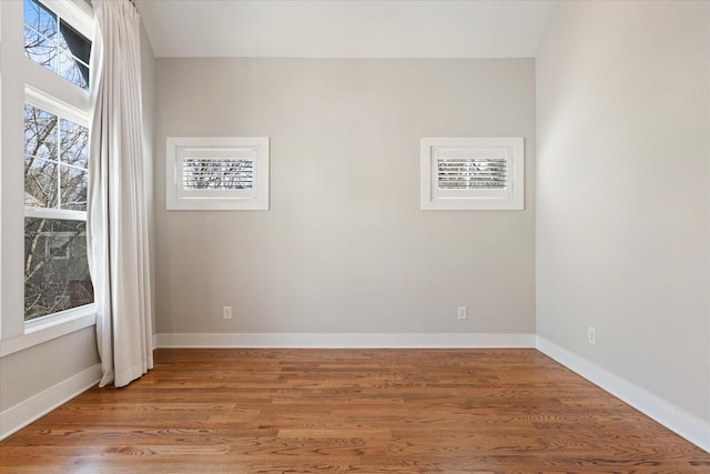 unfurnished room featuring baseboards and light wood-style floors