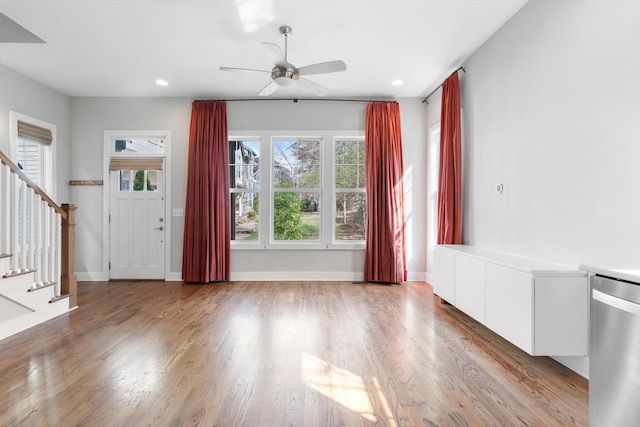 interior space featuring stairway, baseboards, ceiling fan, and wood finished floors