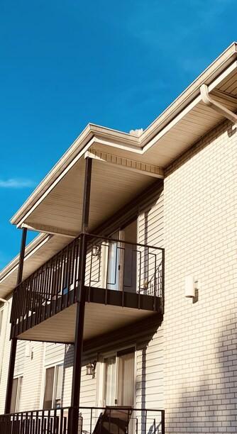 view of home's exterior featuring brick siding and a balcony