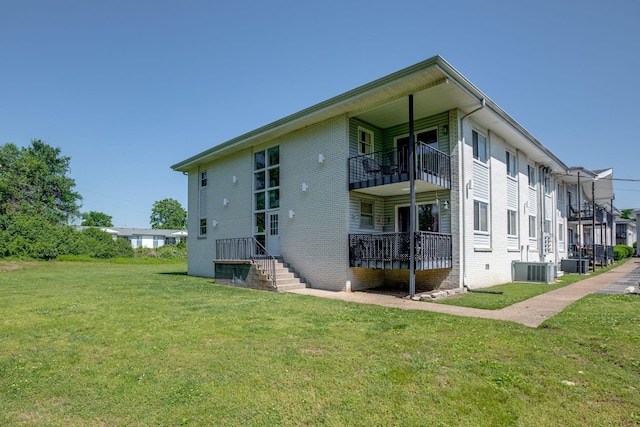 back of house with a lawn, central AC, and a balcony
