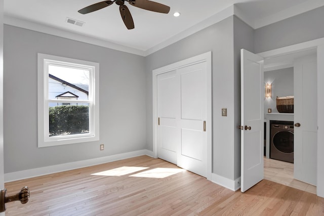 unfurnished bedroom with visible vents, washer / clothes dryer, light wood finished floors, baseboards, and ceiling fan