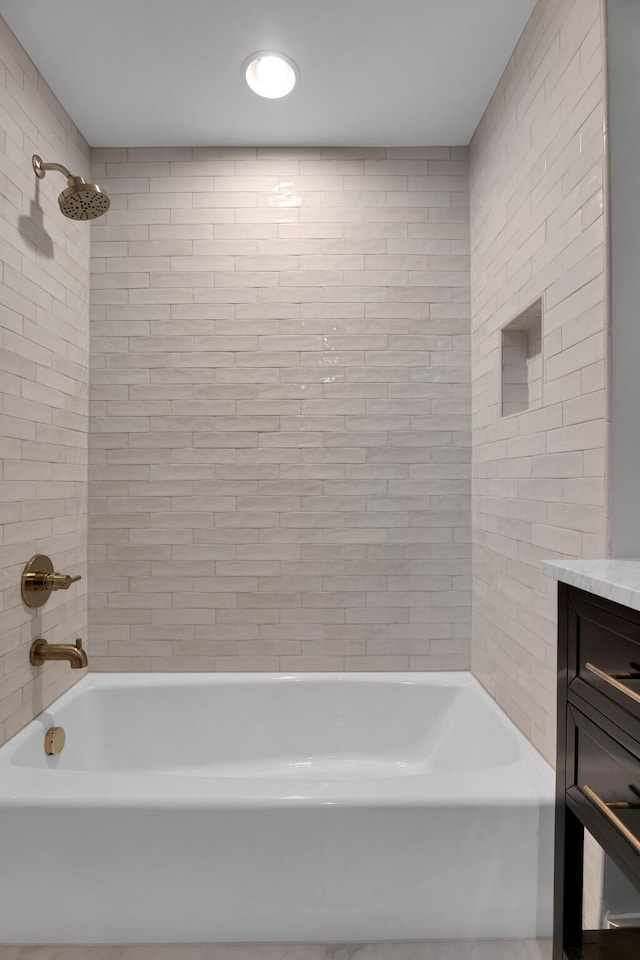 bathroom featuring washtub / shower combination and vanity