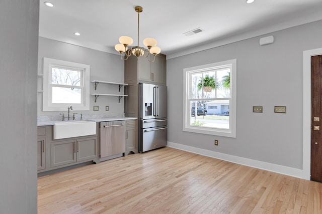 kitchen featuring a sink, stainless steel appliances, visible vents, and a wealth of natural light