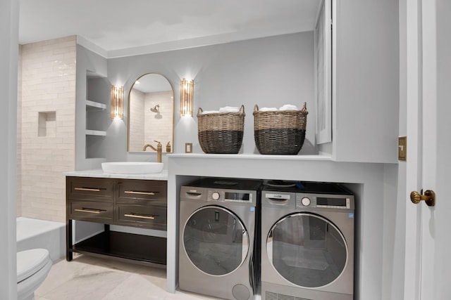 laundry area with laundry area, washer and dryer, and a sink