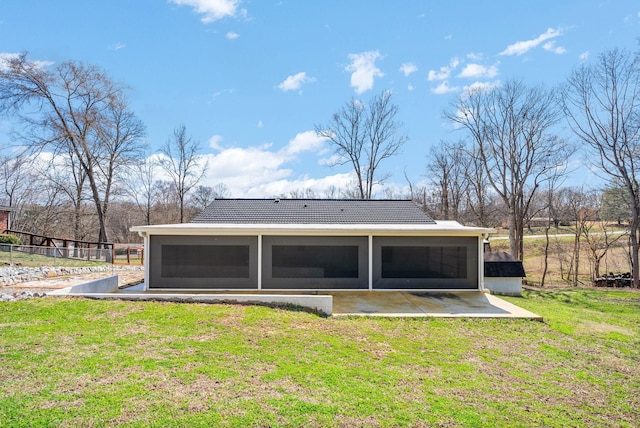 back of property featuring a patio area, a tiled roof, a yard, and a sunroom