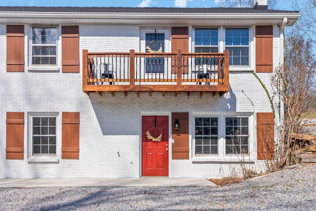 view of front of property with a balcony and brick siding