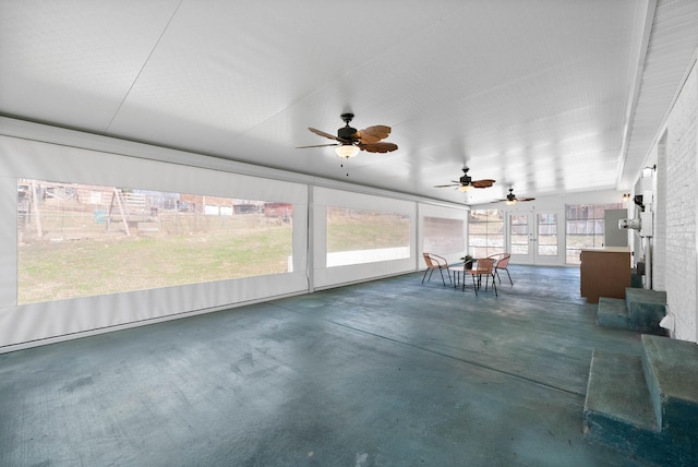 unfurnished sunroom with a ceiling fan