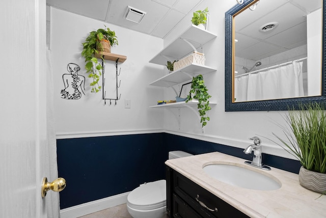 bathroom featuring vanity, toilet, baseboards, and visible vents