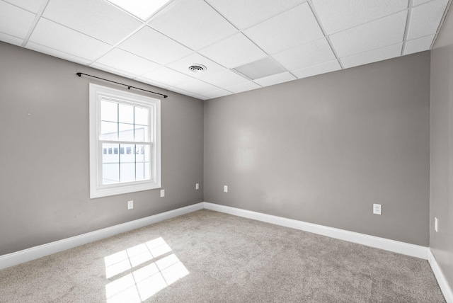 unfurnished room with visible vents, a paneled ceiling, carpet, and baseboards