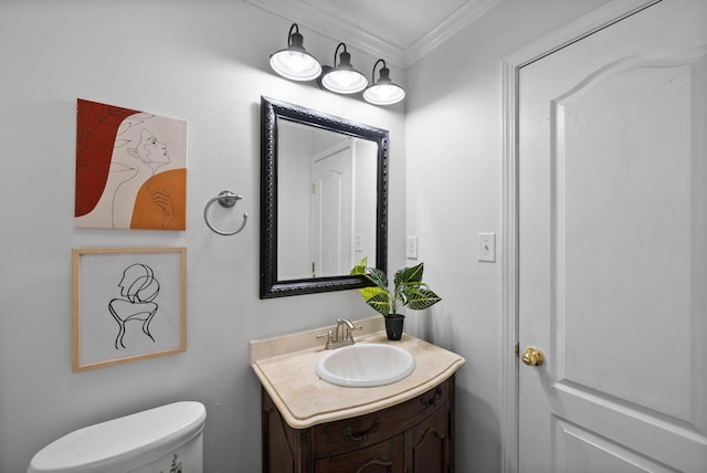 half bath with toilet, vanity, and crown molding