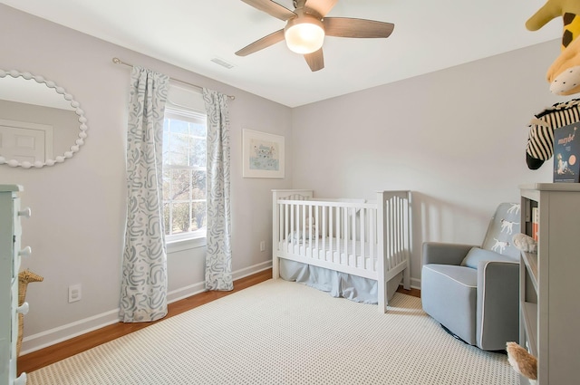 bedroom with a nursery area, multiple windows, baseboards, and visible vents