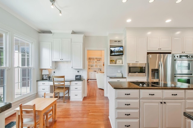 kitchen featuring ornamental molding, decorative backsplash, stainless steel appliances, white cabinetry, and light wood-type flooring