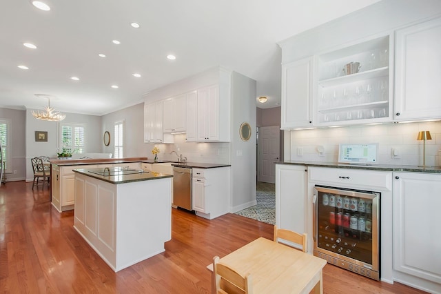 kitchen featuring dark countertops, wine cooler, a peninsula, an inviting chandelier, and dishwasher