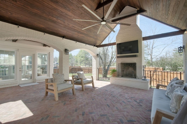 view of patio / terrace with a ceiling fan, an outdoor brick fireplace, and fence