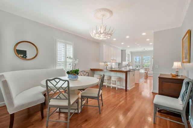 dining area with recessed lighting, a notable chandelier, light wood-style flooring, and ornamental molding