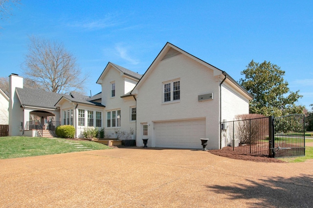 back of house with brick siding, fence, concrete driveway, a yard, and an attached garage