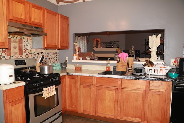 kitchen with dishwashing machine, a sink, under cabinet range hood, gas range, and tasteful backsplash