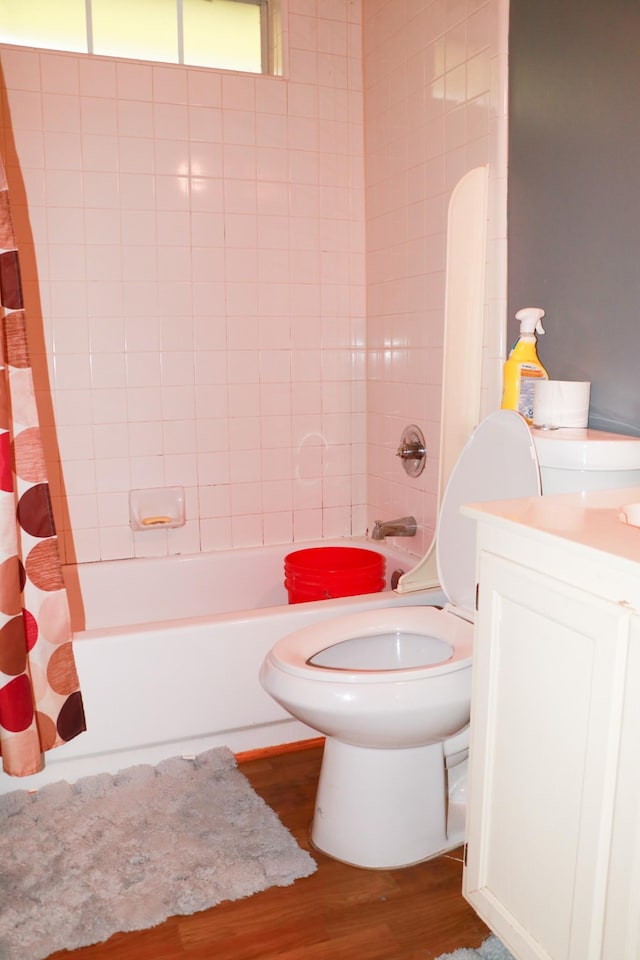 bathroom with shower / tub combo with curtain, wood finished floors, vanity, and toilet