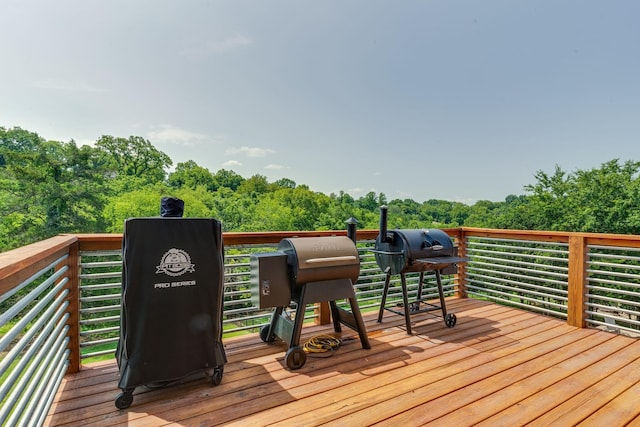 deck with a view of trees and a grill