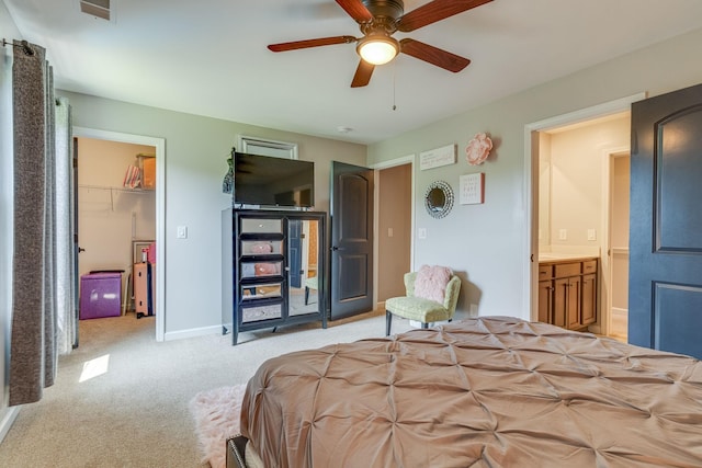 bedroom featuring visible vents, ceiling fan, baseboards, light carpet, and ensuite bath