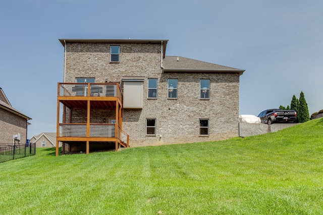 back of house featuring brick siding, a lawn, and a balcony