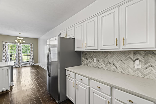 kitchen with a chandelier, backsplash, white cabinets, and freestanding refrigerator