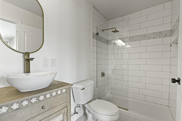 bathroom with toilet, vanity, and a tile shower