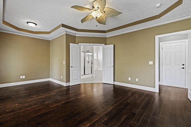 spare room featuring a ceiling fan, a textured ceiling, wood finished floors, crown molding, and a raised ceiling