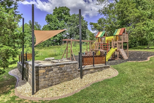 view of playground with a fire pit and a lawn