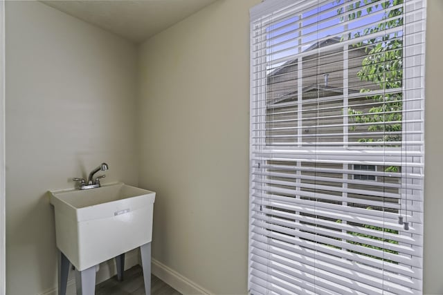 laundry area with a sink and baseboards