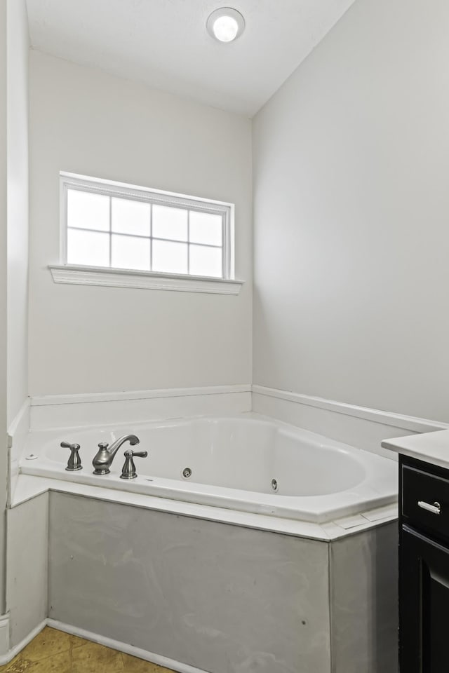 bathroom with a jetted tub and vanity