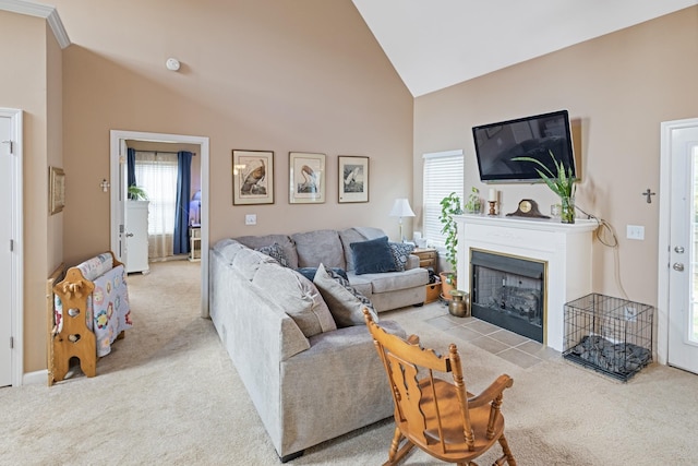 carpeted living room featuring a wealth of natural light, a fireplace with flush hearth, and high vaulted ceiling