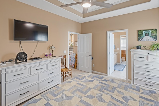 bedroom with baseboards, ensuite bath, ceiling fan, ornamental molding, and a raised ceiling