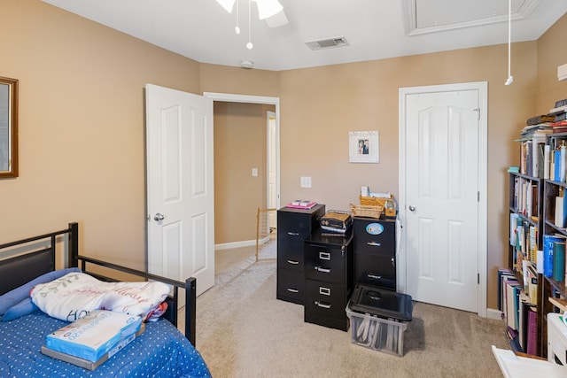 carpeted bedroom with visible vents, attic access, baseboards, and a ceiling fan