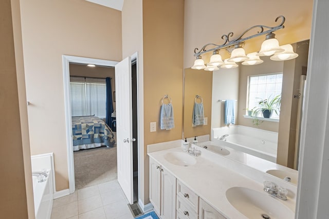 ensuite bathroom with a bath, tile patterned floors, double vanity, and a sink