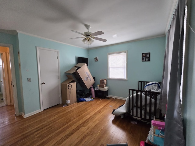 bedroom featuring ornamental molding, baseboards, and wood finished floors